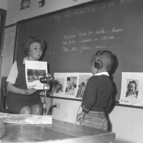 Fotografía de una maestra enseñando a un niño a hablar
